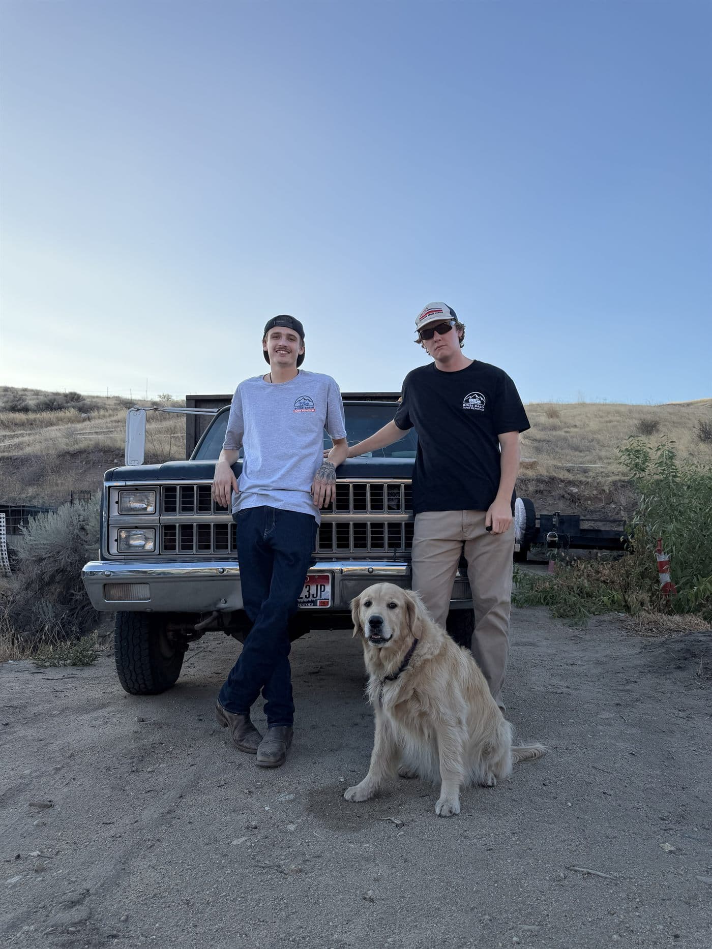 The Boise Basin Junk Removal crew with their hauling truck and dog